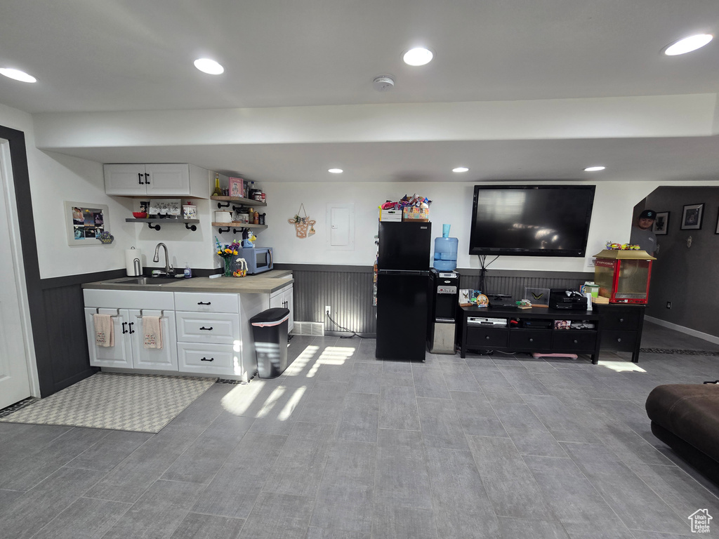 Interior space with a wainscoted wall, wet bar, and recessed lighting