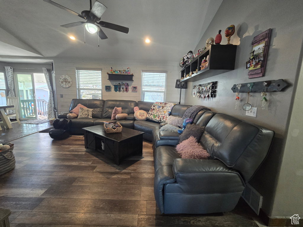 Living area with visible vents, vaulted ceiling, ceiling fan, and dark wood finished floors
