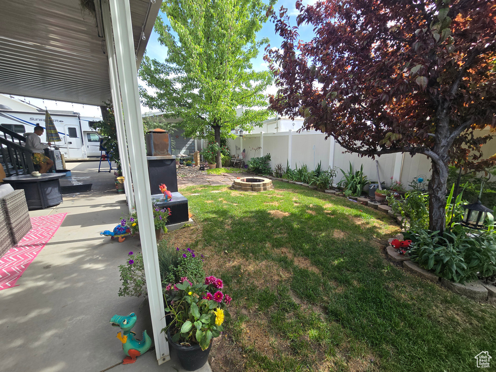 Fenced backyard with a fire pit and a patio