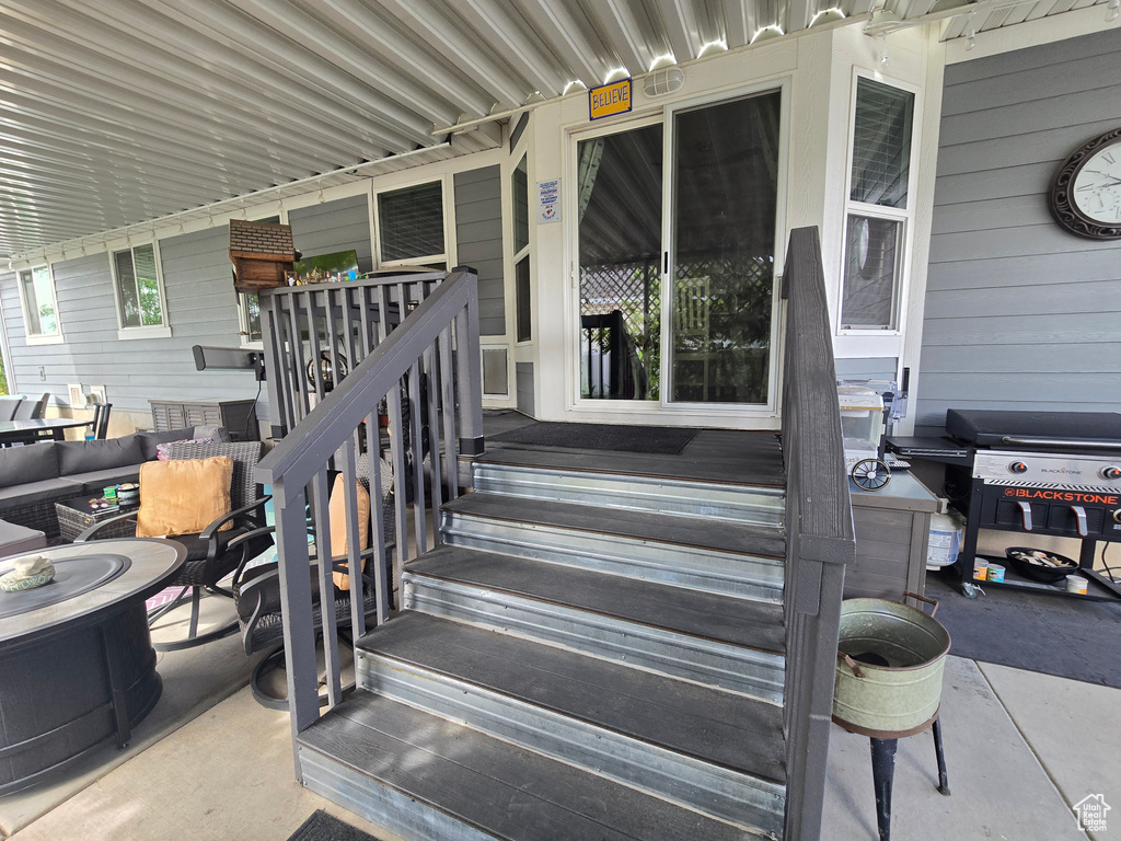 View of exterior entry with covered porch and an outdoor living space