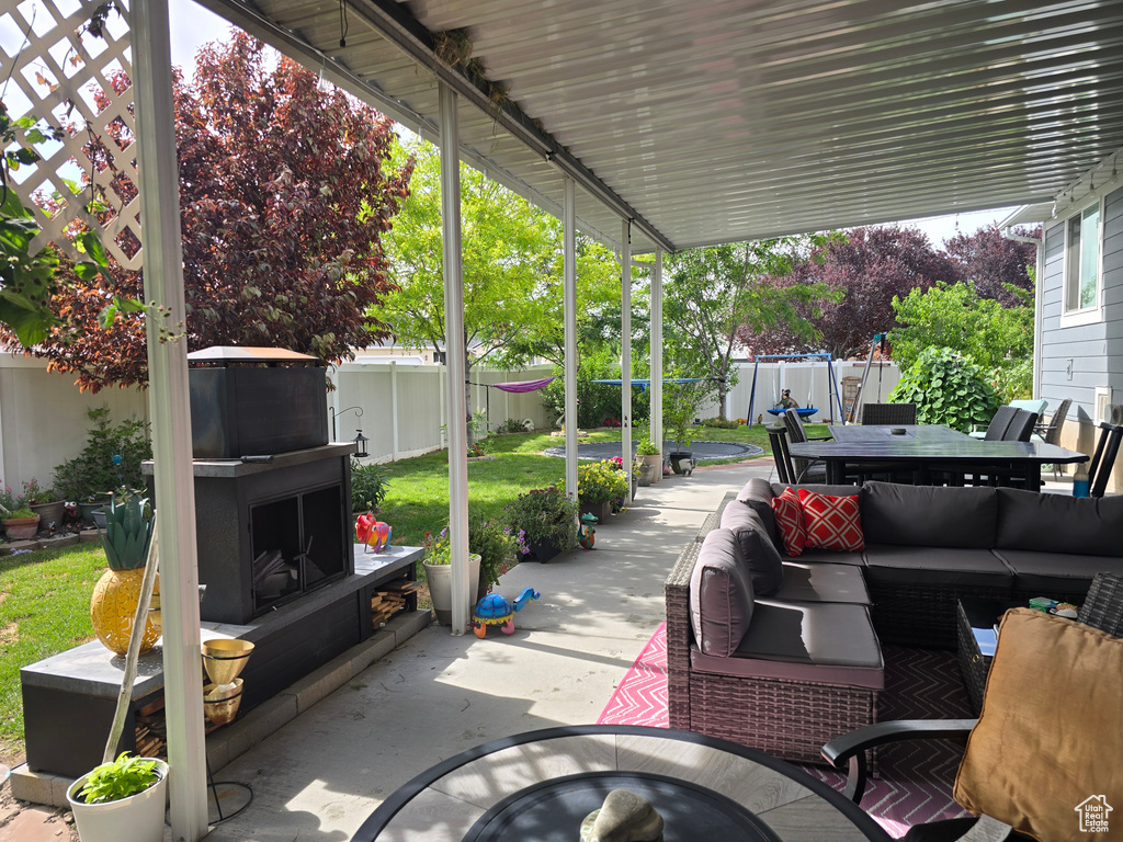 Fenced backyard featuring an outdoor living space with a fireplace, outdoor dining area, and a patio area