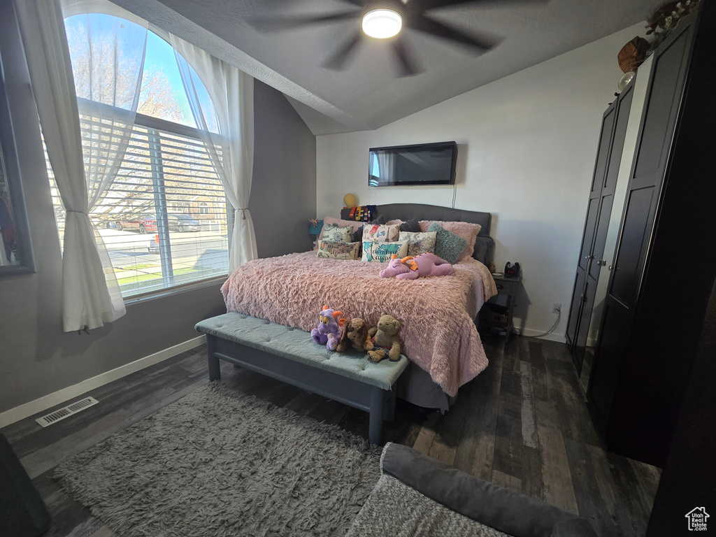 Bedroom featuring baseboards, vaulted ceiling, visible vents, and dark wood-type flooring
