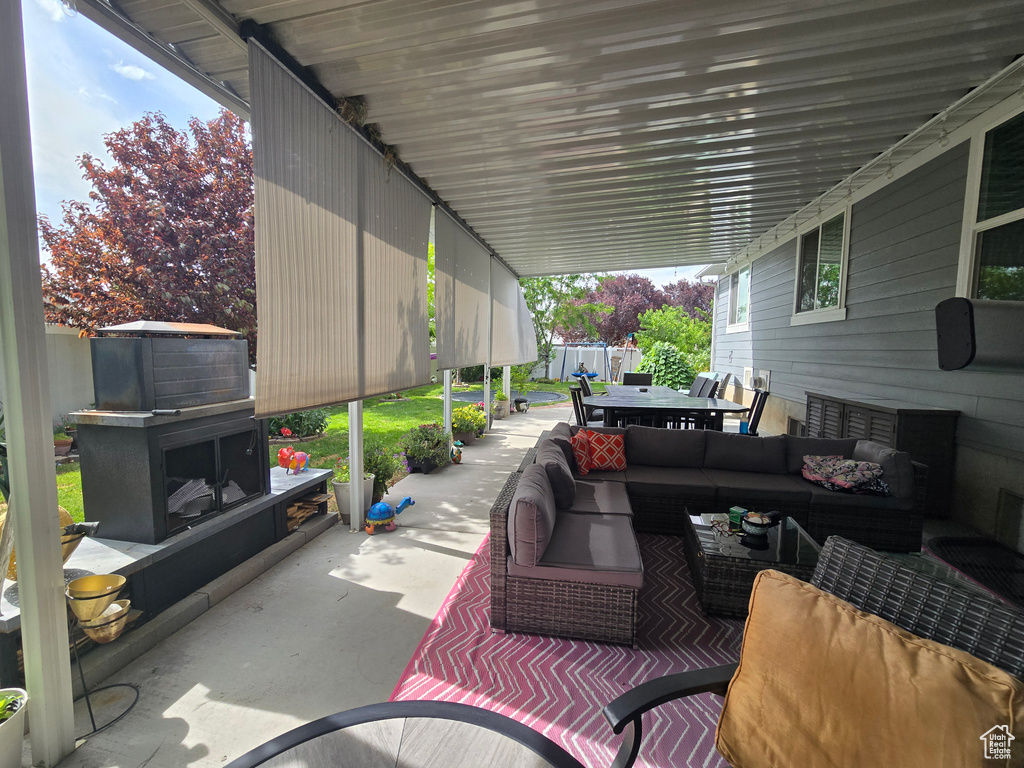 View of patio with an outdoor living space with a fireplace and outdoor dining area