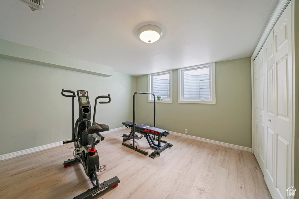 Workout area featuring visible vents, baseboards, and light wood finished floors