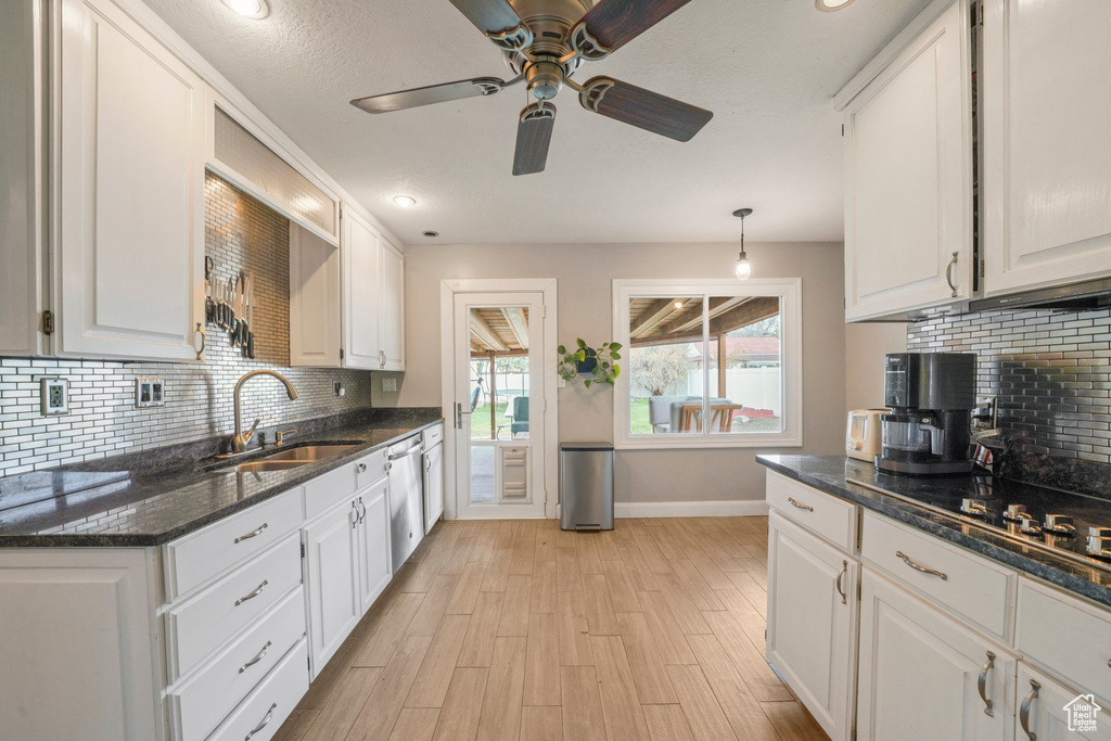 Kitchen with light wood-style flooring, white cabinets, a ceiling fan, and a sink