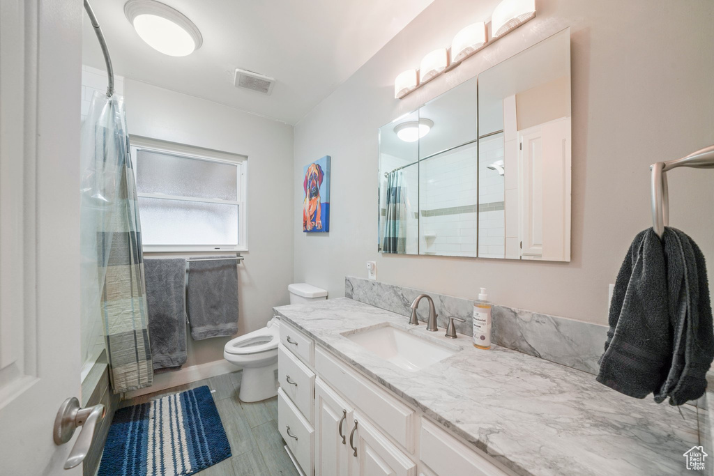 Full bathroom featuring visible vents, curtained shower, toilet, and vanity