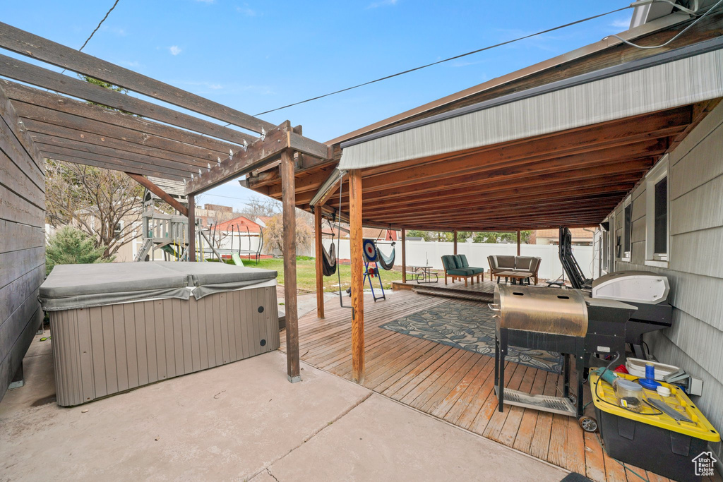 View of patio with a hot tub, fence, a deck, and a pergola