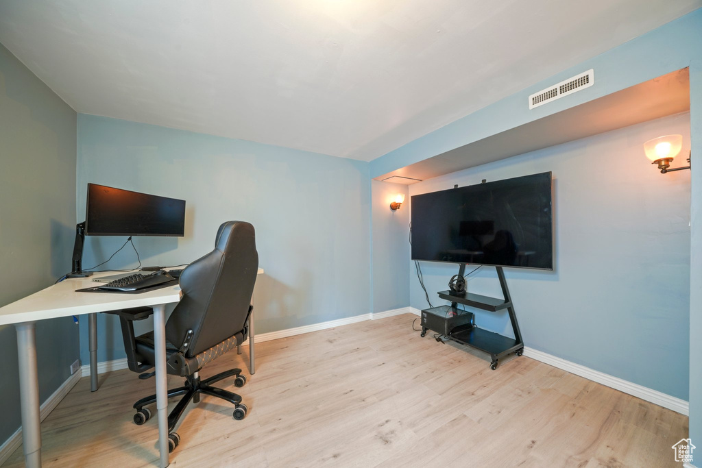 Office space with visible vents, baseboards, and wood finished floors