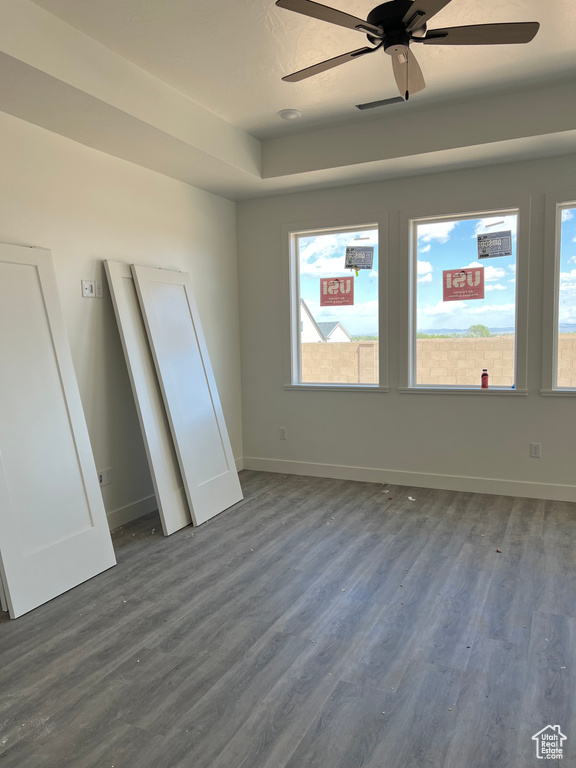 Unfurnished bedroom with dark wood-style flooring, multiple windows, and baseboards