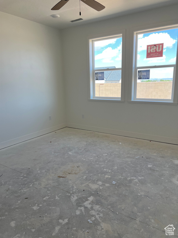 Unfurnished room featuring a ceiling fan and baseboards