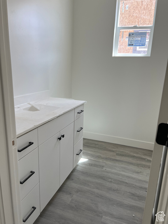 Bathroom featuring wood finished floors, baseboards, and vanity