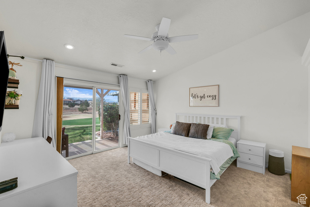 Bedroom with light colored carpet, access to exterior, visible vents, and lofted ceiling