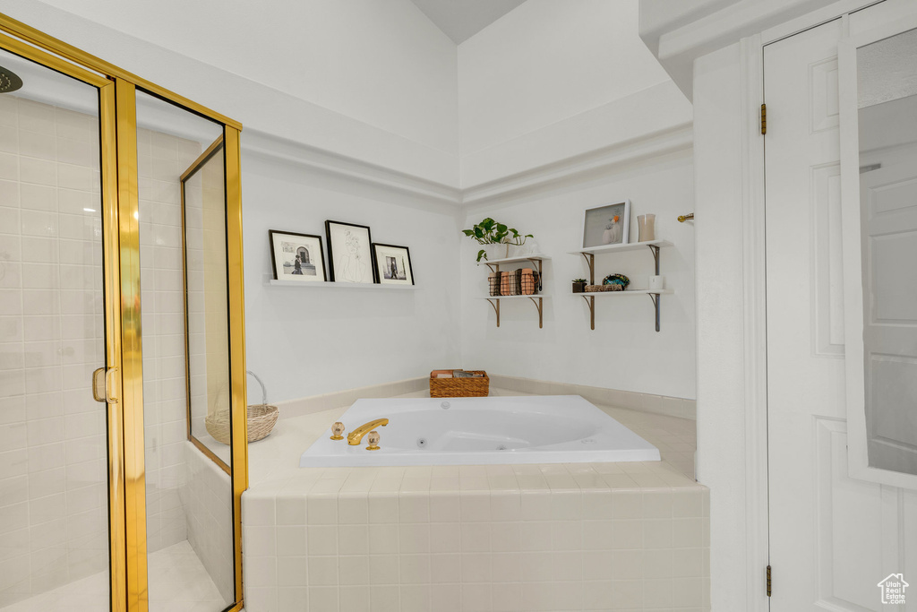 Full bathroom featuring a jetted tub and a shower stall