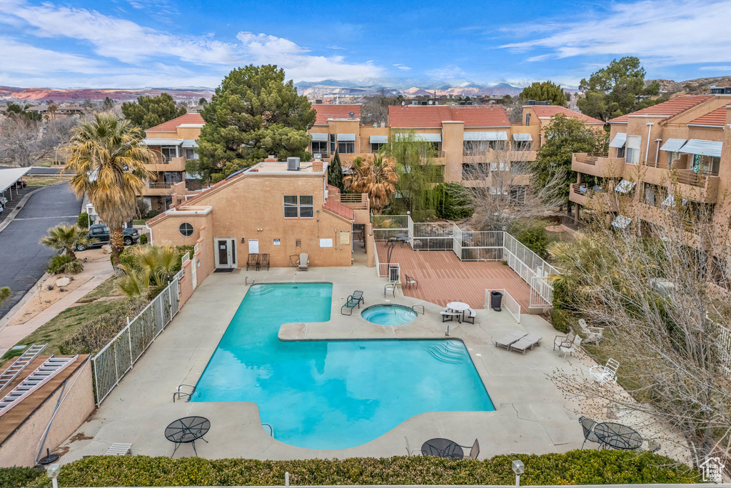 Community pool featuring a hot tub and a patio