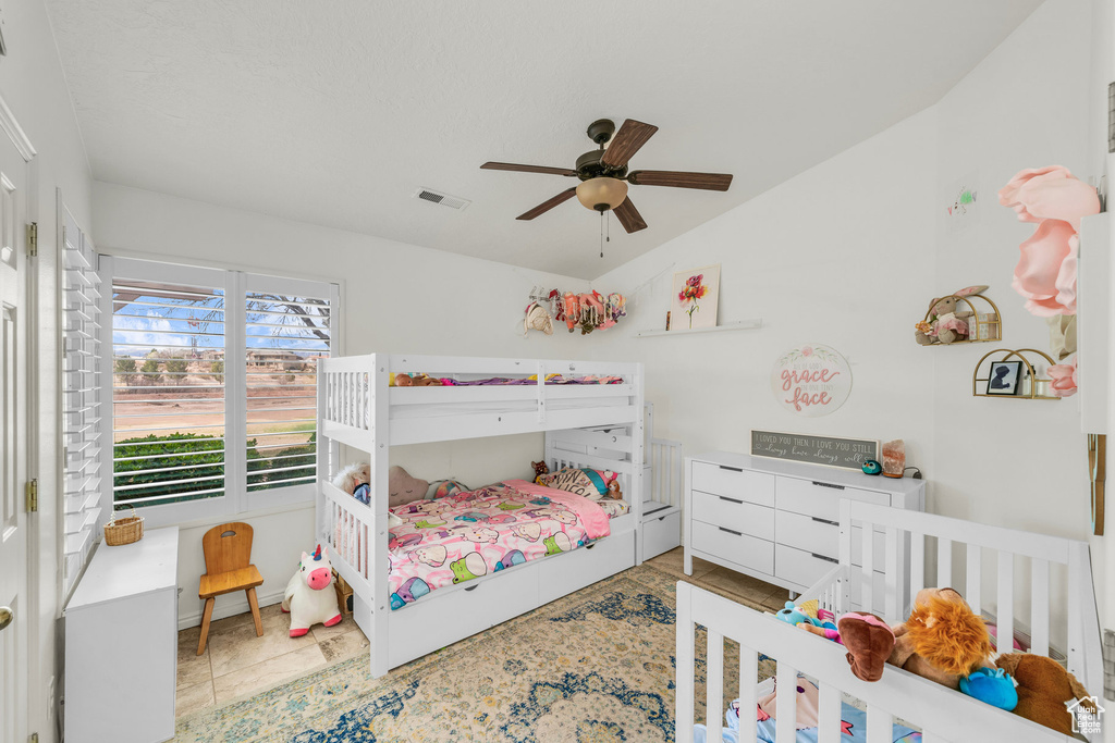 Bedroom with lofted ceiling, ceiling fan, and visible vents