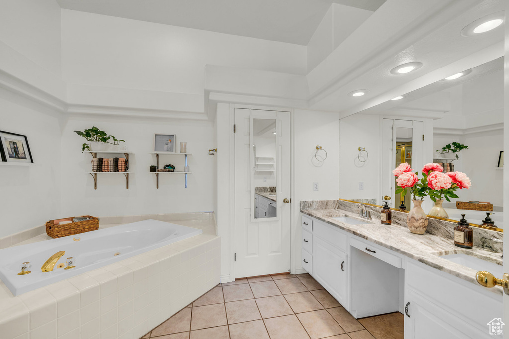 Bathroom featuring double vanity, a sink, tile patterned floors, and a whirlpool tub