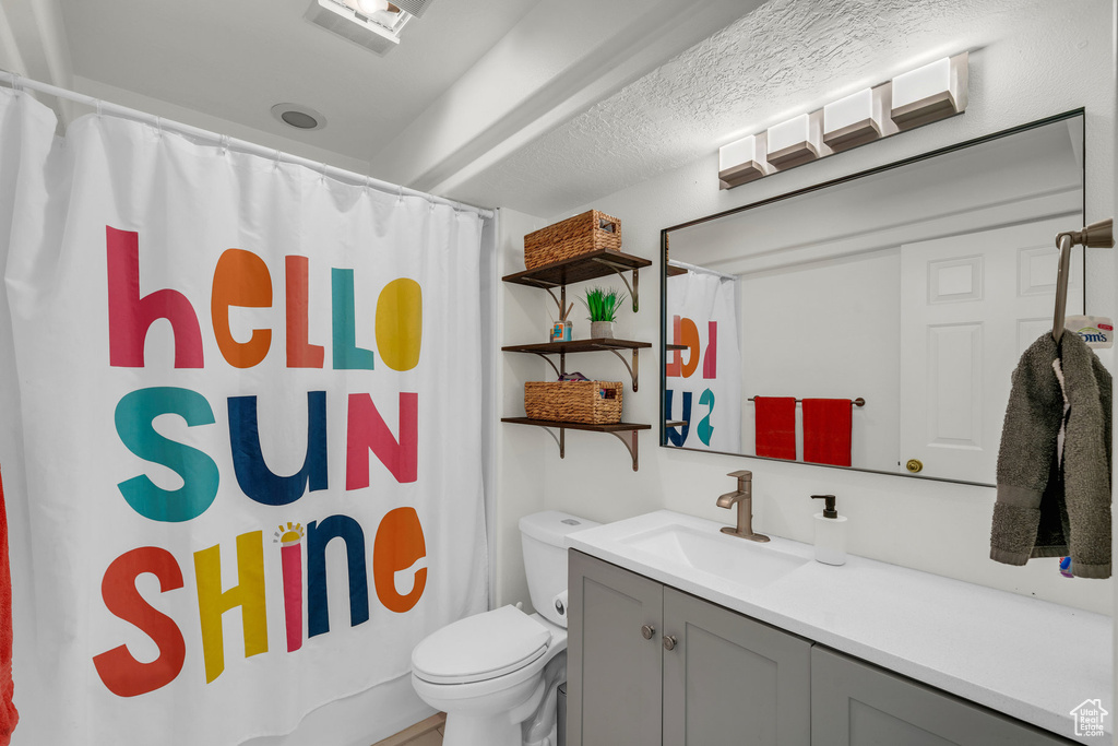 Bathroom with a shower with shower curtain, toilet, and vanity