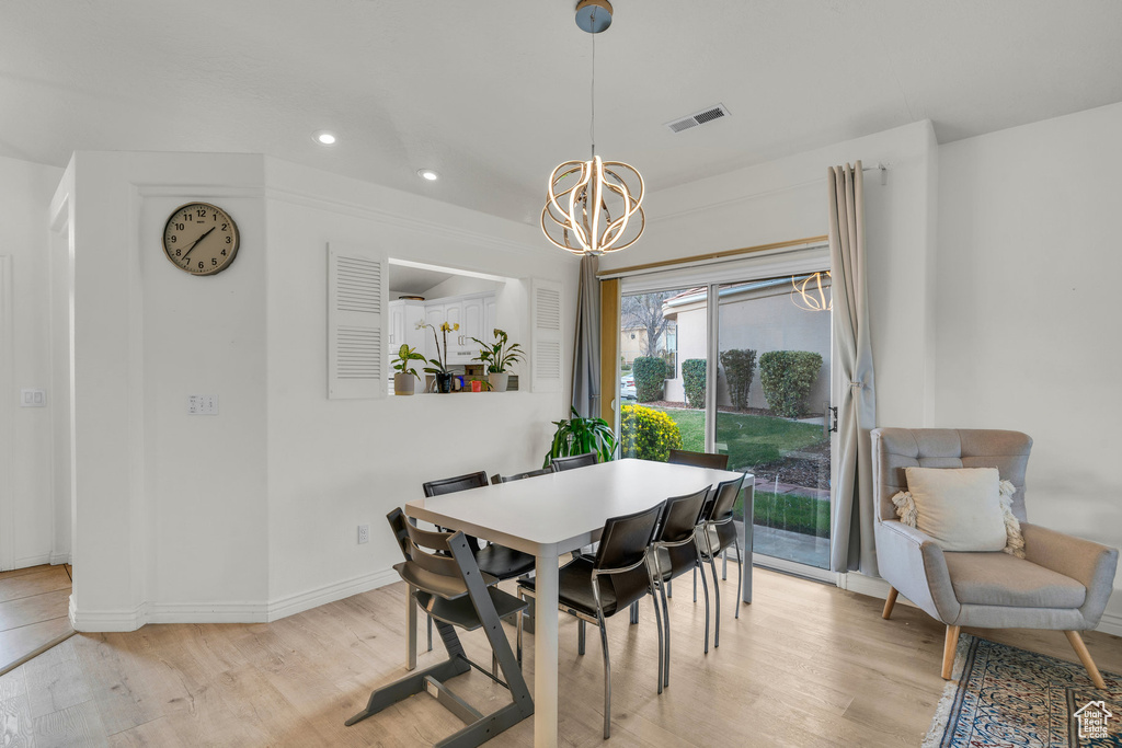 Dining space featuring visible vents, light wood finished floors, baseboards, recessed lighting, and an inviting chandelier