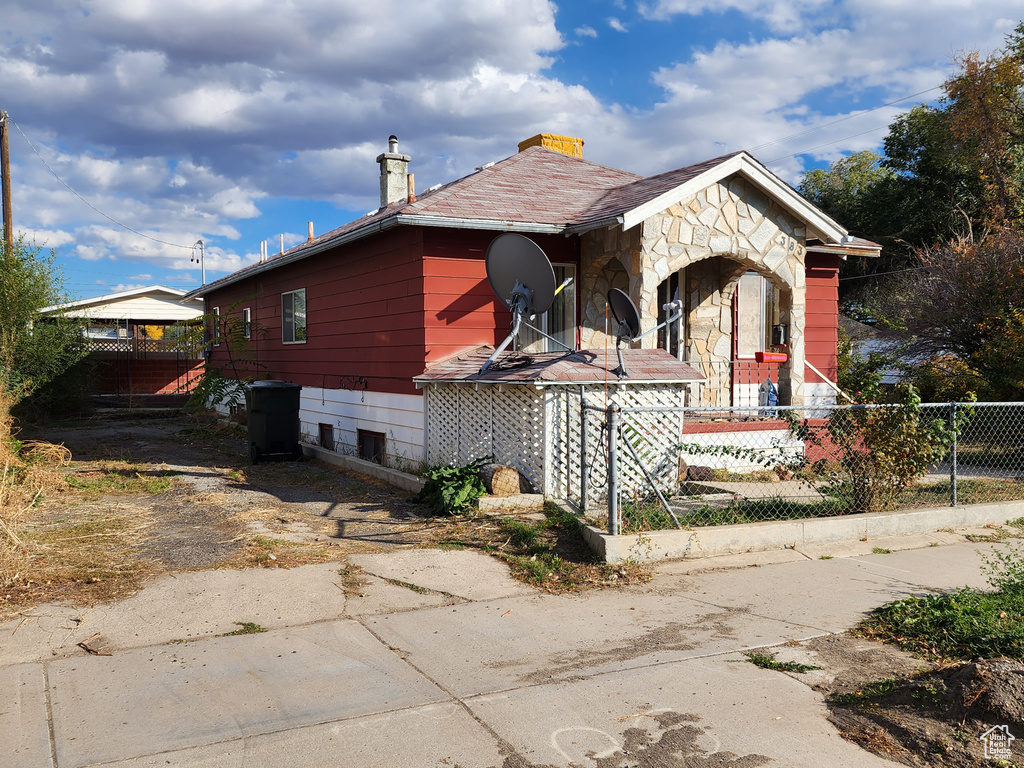 View of front of house with a chimney and stone siding