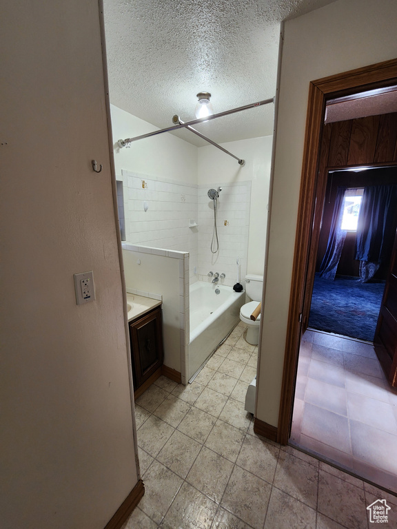 Full bath featuring shower / washtub combination, a textured ceiling, toilet, vanity, and baseboards