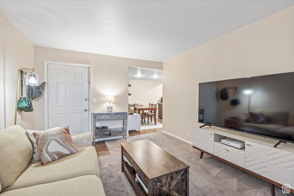 Living room with baseboards and light colored carpet