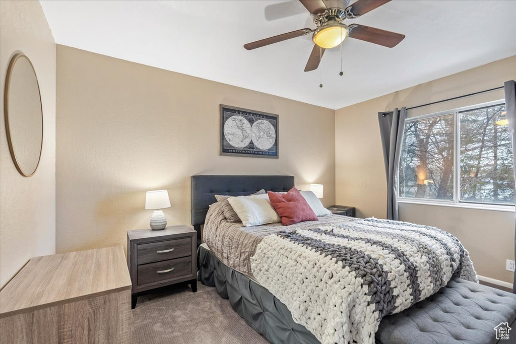 Bedroom with baseboards, a ceiling fan, and light colored carpet