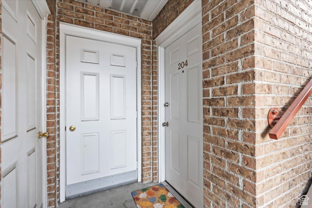 View of exterior entry with brick siding