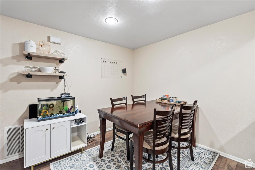 Dining room featuring wood finished floors, baseboards, and visible vents
