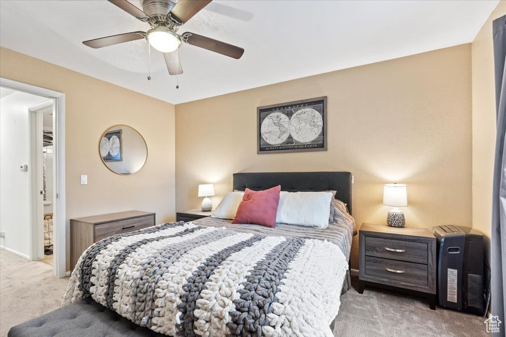 Bedroom featuring baseboards, light colored carpet, and ceiling fan