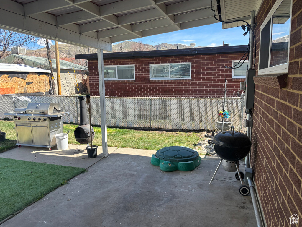 View of patio with a grill and fence