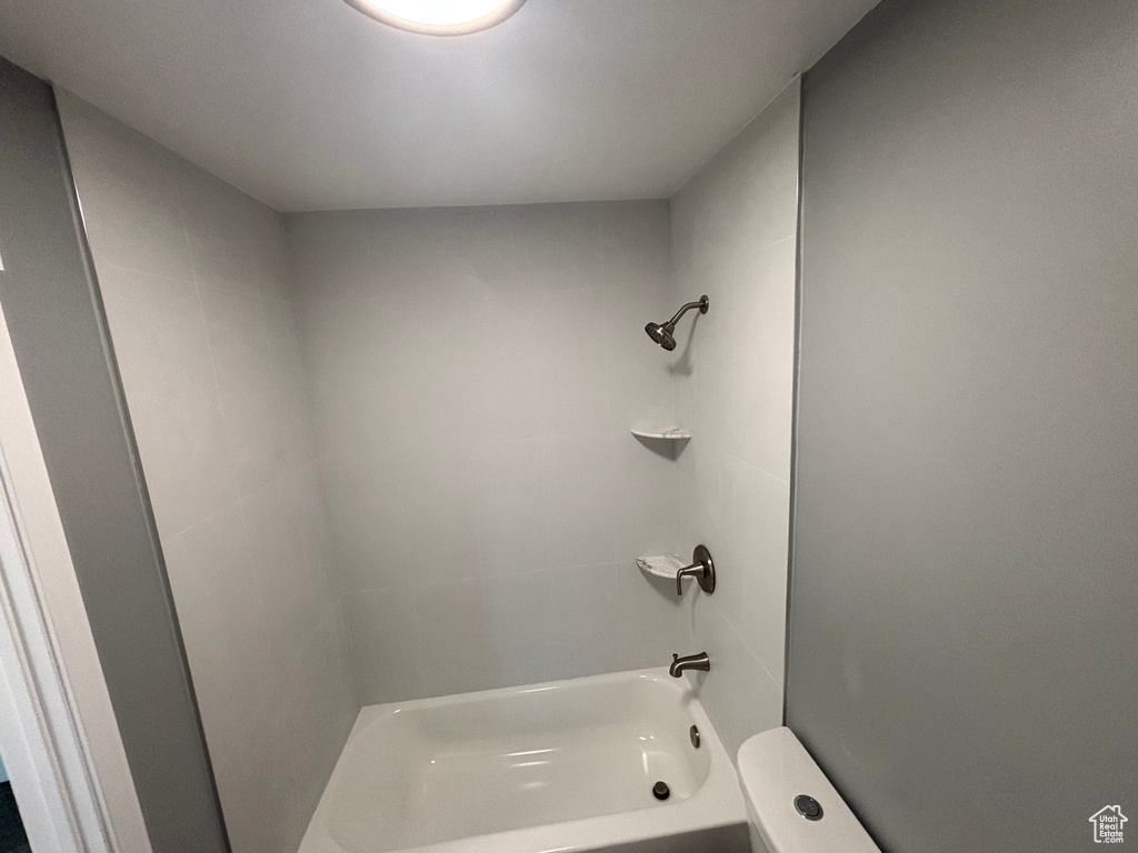 Bathroom featuring toilet and washtub / shower combination
