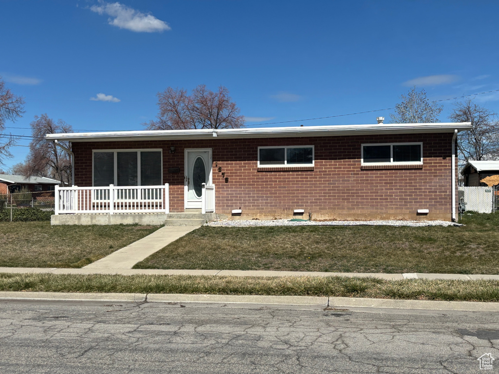 Ranch-style home featuring a front lawn, crawl space, a porch, and brick siding