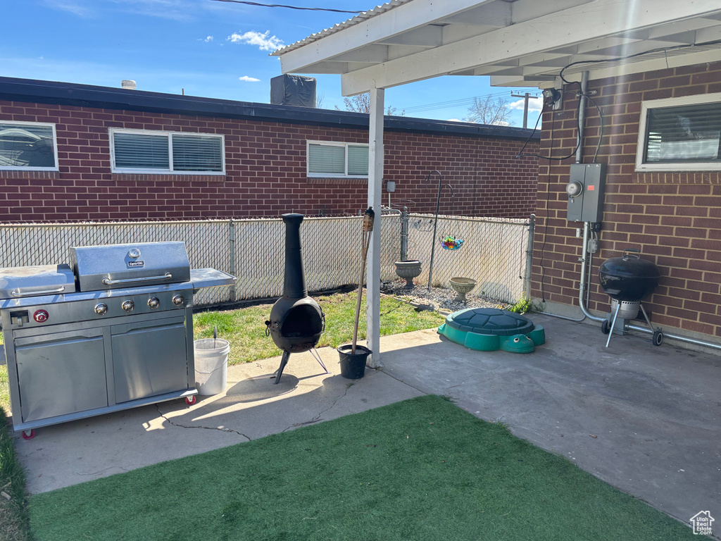 View of patio / terrace featuring area for grilling and fence