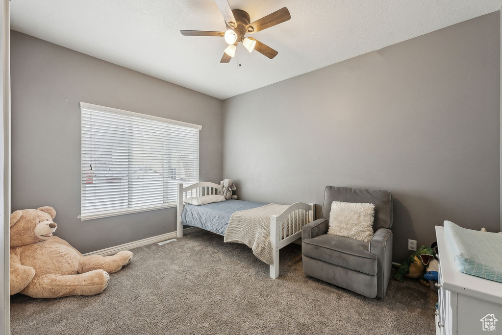 Bedroom featuring baseboards, carpet floors, and a ceiling fan