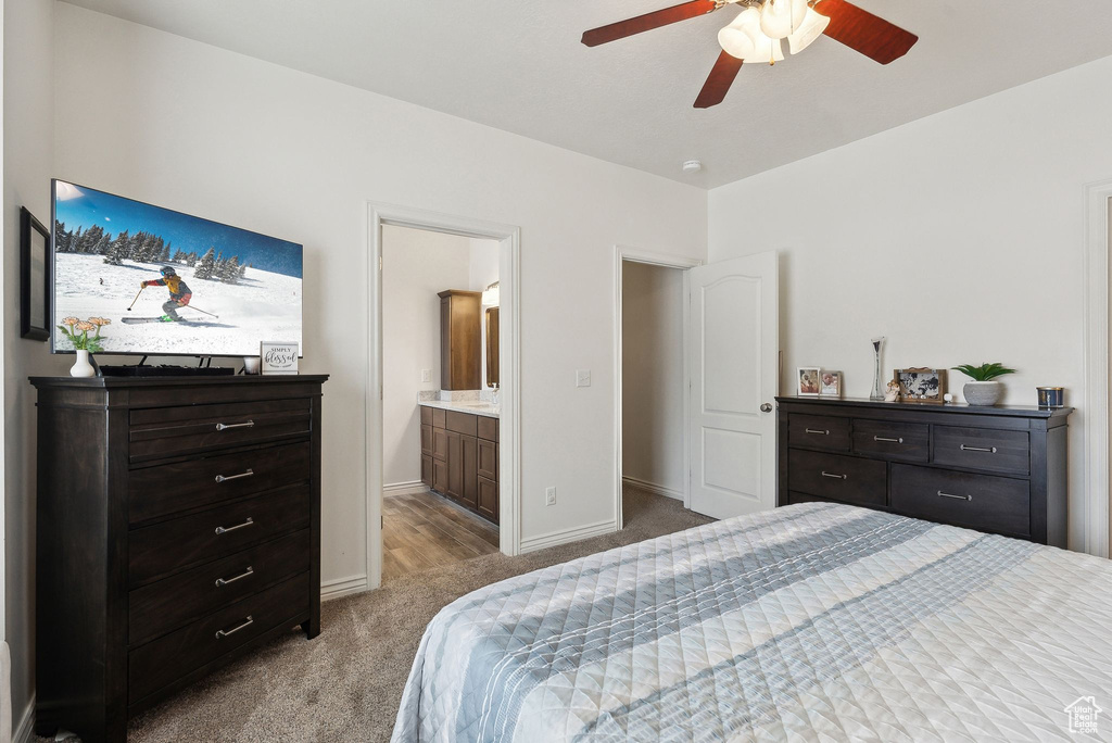 Bedroom featuring baseboards, ensuite bath, carpet, and a ceiling fan