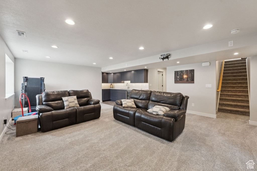 Living room featuring stairs, recessed lighting, visible vents, light carpet, and indoor wet bar