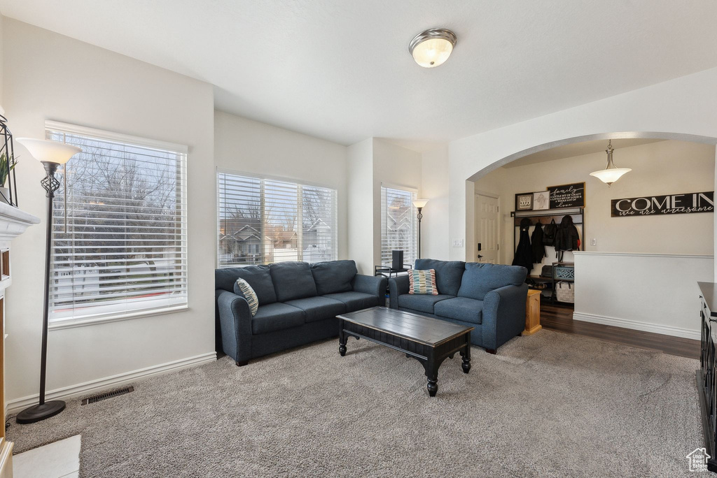 Living room featuring arched walkways, baseboards, and visible vents