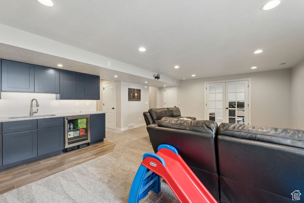 Living area featuring wine cooler, indoor wet bar, light colored carpet, visible vents, and recessed lighting