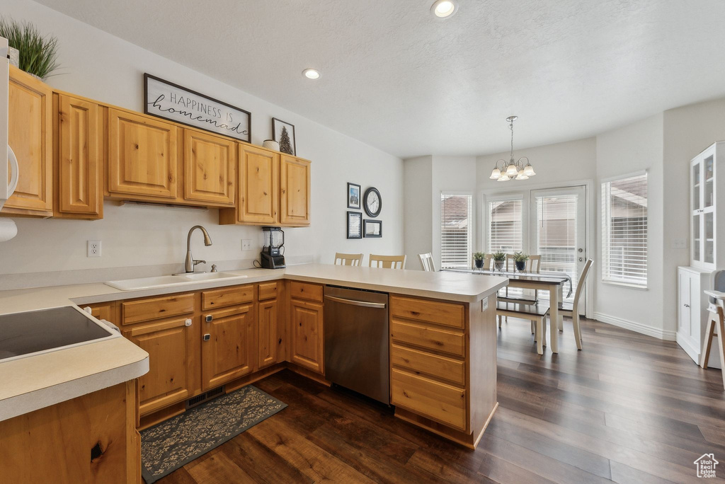 Kitchen with light countertops, a peninsula, dishwasher, dark wood finished floors, and a sink