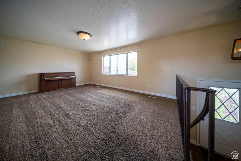 Carpeted spare room with baseboards and a textured ceiling