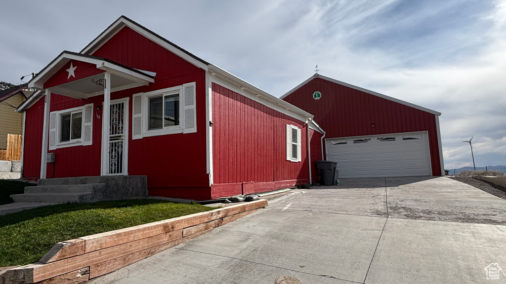 View of front of property featuring an outdoor structure, driveway, and entry steps