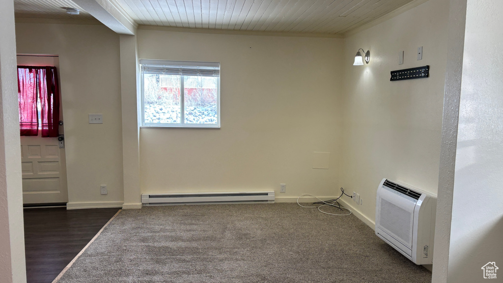 Unfurnished room featuring baseboards, a baseboard heating unit, wood ceiling, and dark wood finished floors