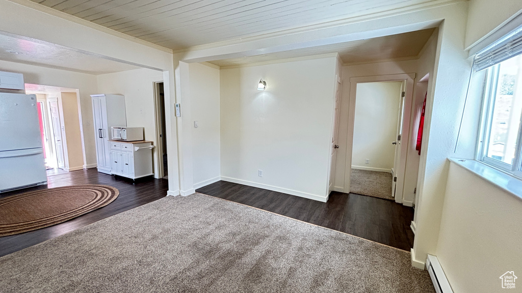 Interior space featuring a baseboard radiator, dark wood-style floors, and a wealth of natural light