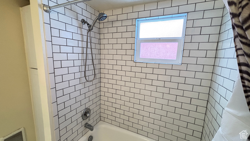 Bathroom featuring visible vents and shower / tub combo