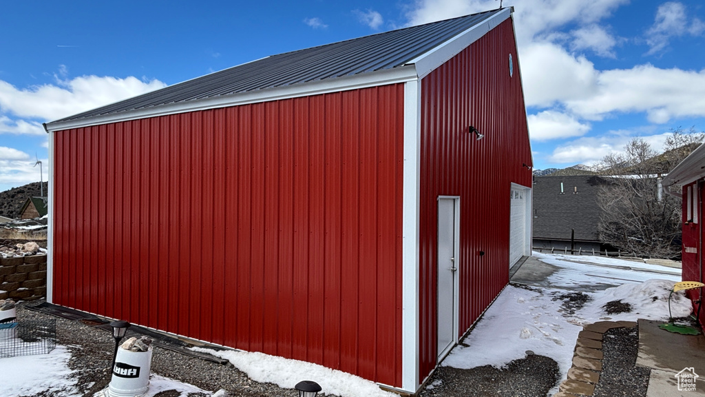Snow covered structure with an outdoor structure and an outbuilding