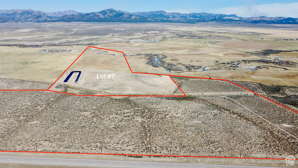 Aerial view of sparsely populated area with a mountain backdrop and property parcel outlined