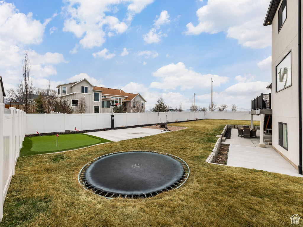 View of yard featuring a fenced backyard, a balcony, and a patio