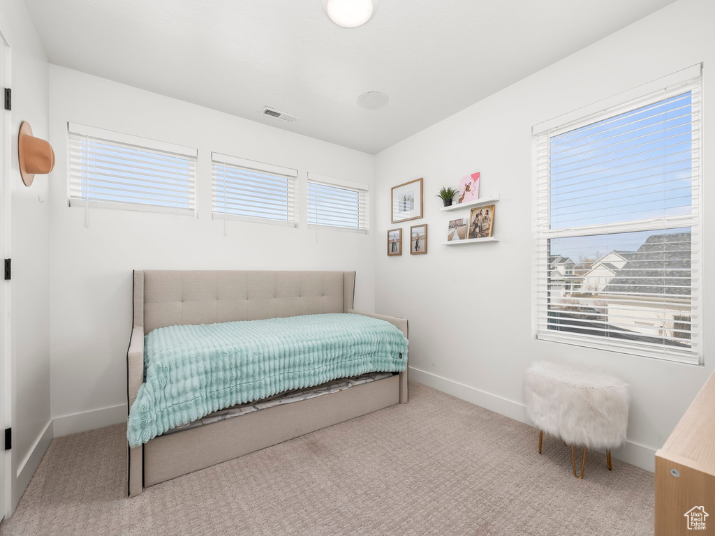 Carpeted bedroom featuring baseboards and visible vents