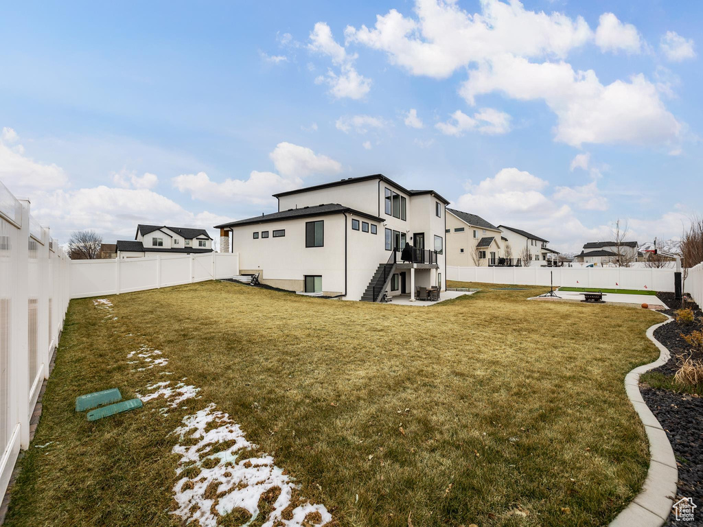 View of yard featuring a patio, a fenced backyard, stairway, and a residential view