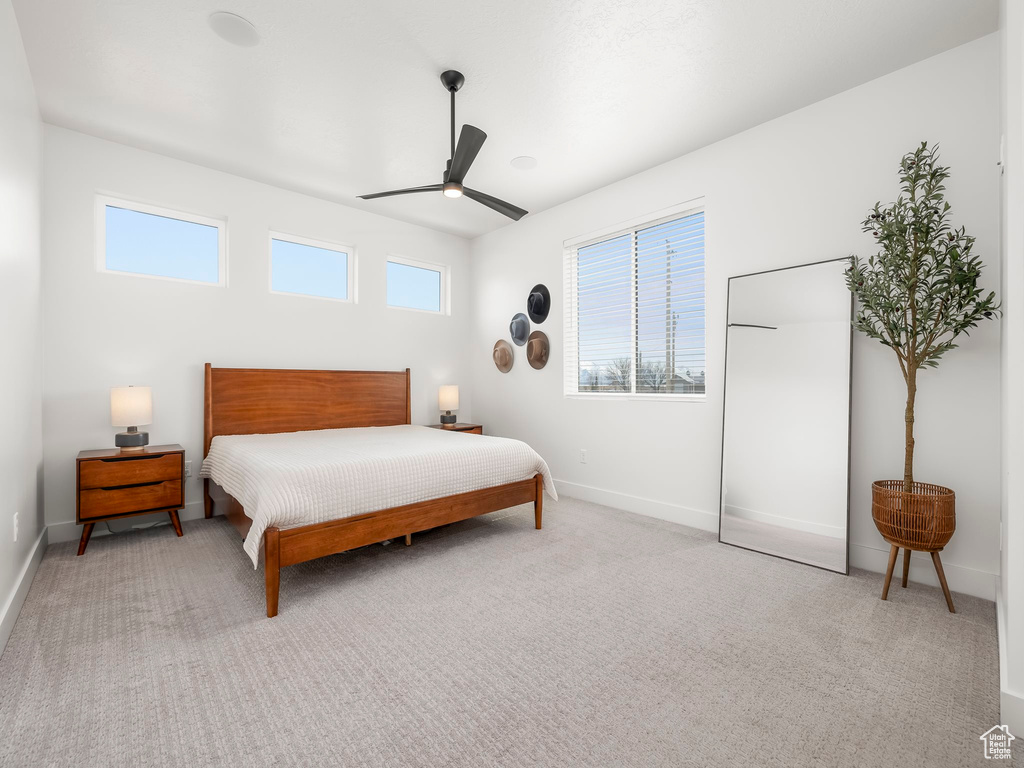 Bedroom featuring baseboards, carpet flooring, ceiling fan, and multiple windows